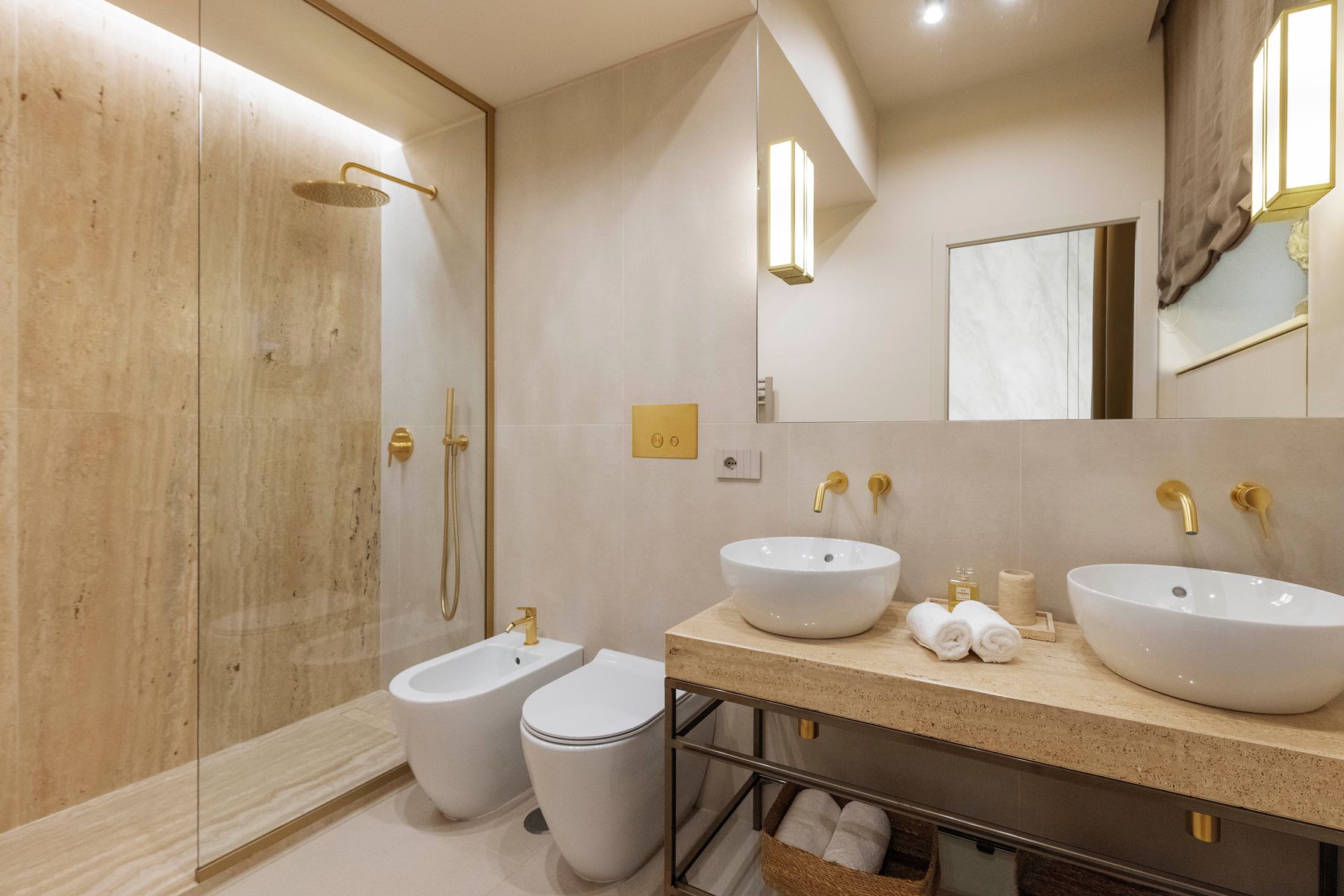 Travertine bathroom with brass double vanity